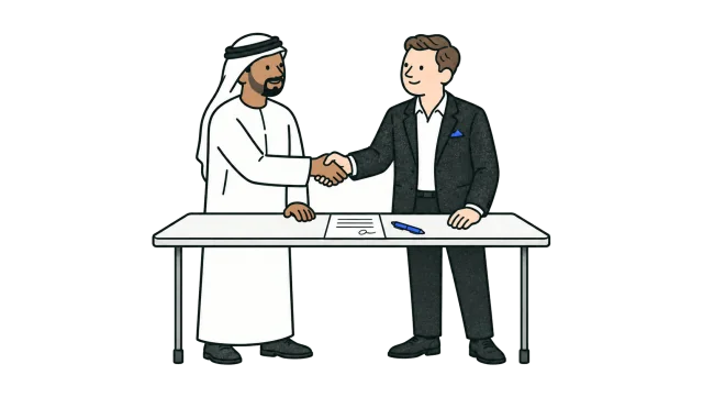 An Emirati businessman and a founder shake hands across a desk with a signed document on it